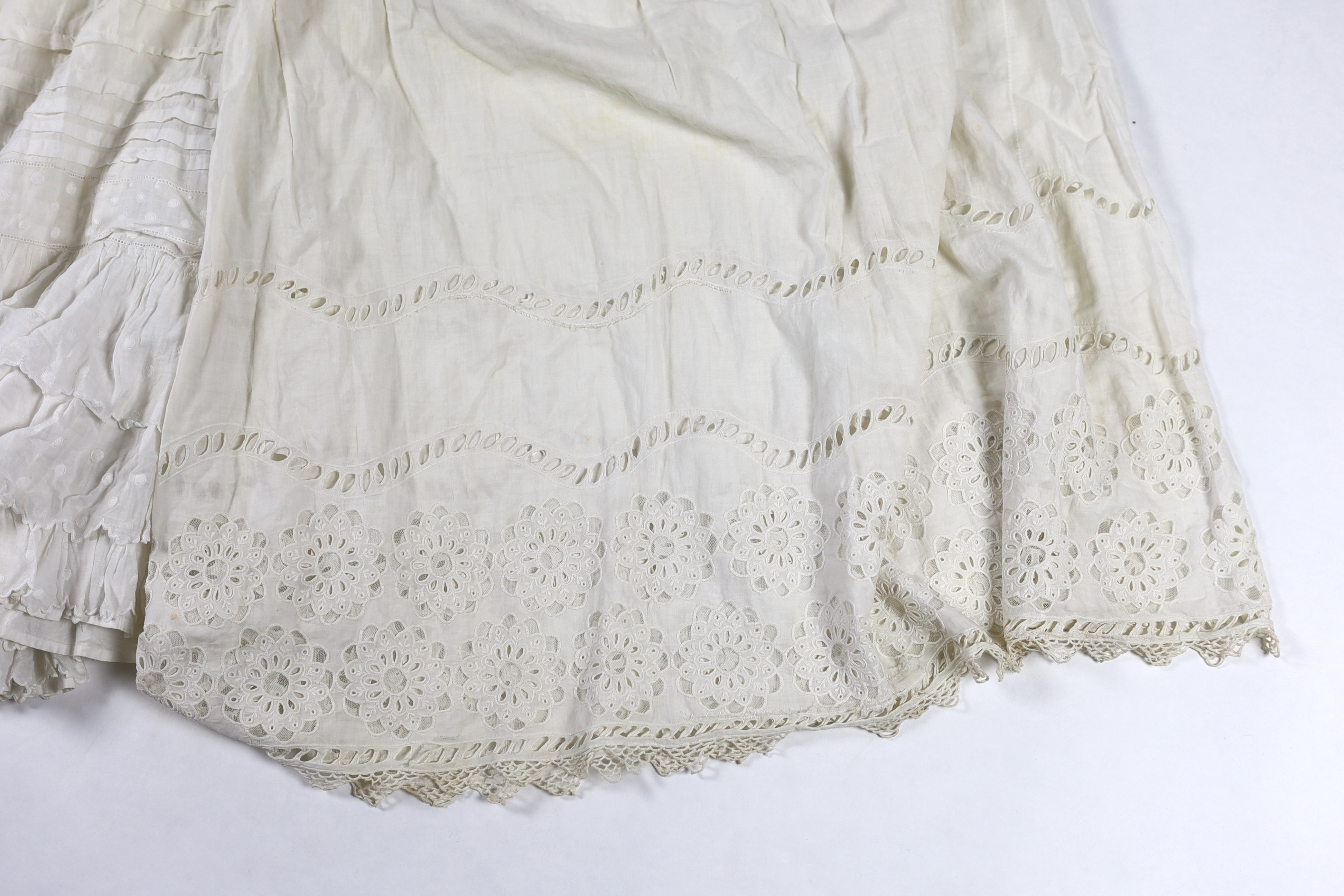 Three Victorian white worked petticoats; one two tiered, one lace trimmed with ribboning, the third worked with cutwork border, all approx. 94cm long